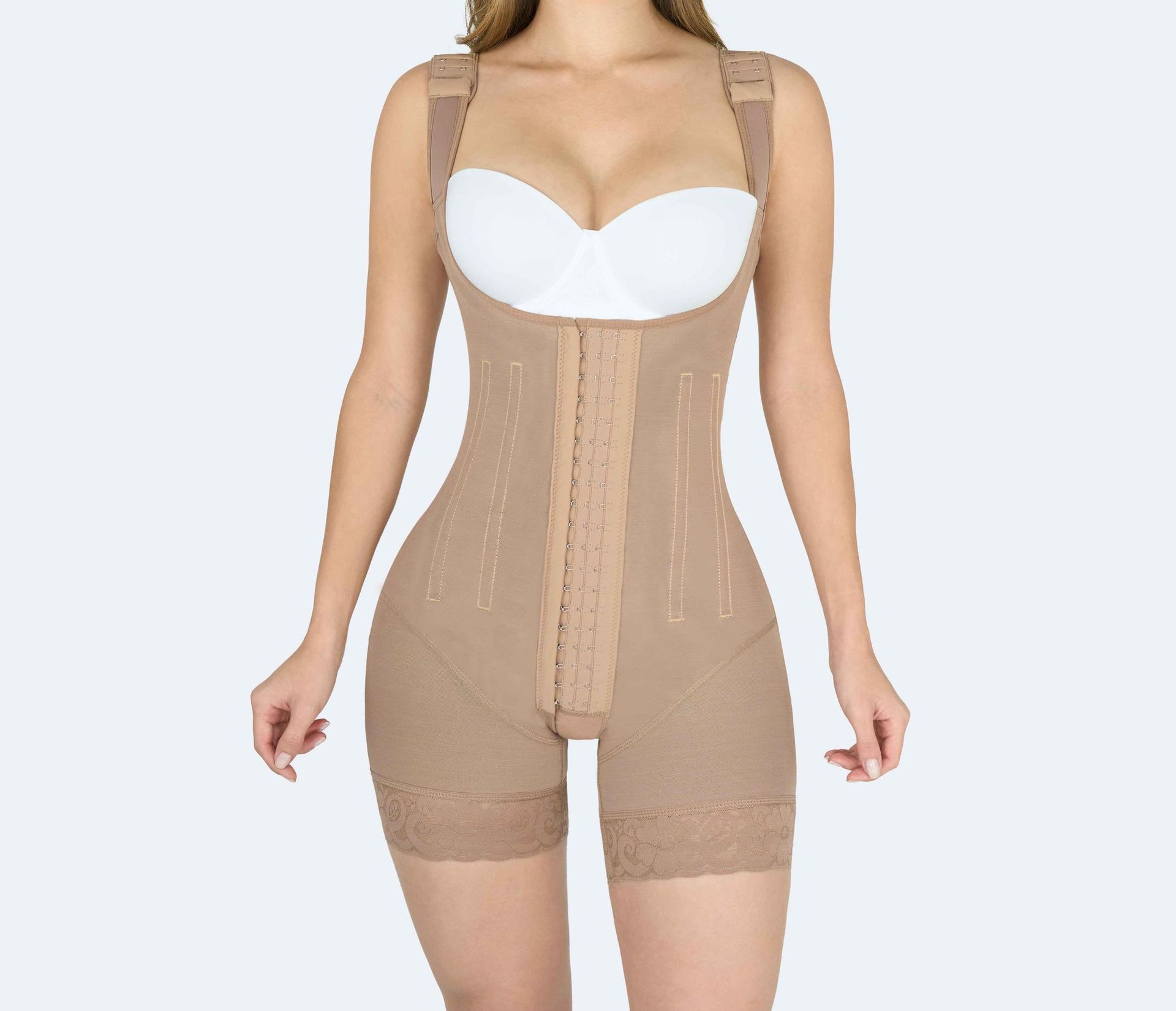 Tan body shaper garment worn by a person, featuring front closure and adjustable straps.
