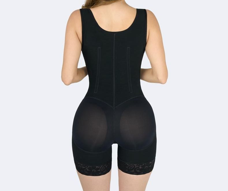 Black shapewear bodysuit on a person, featuring a butt lift and lace trim on legs.