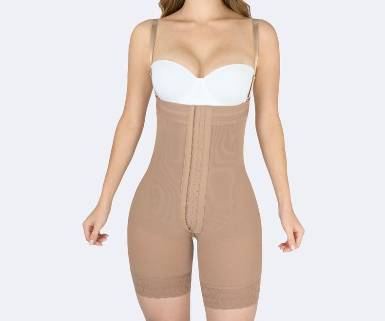 Woman wearing a beige body shaper with adjustable straps, standing against a light background.