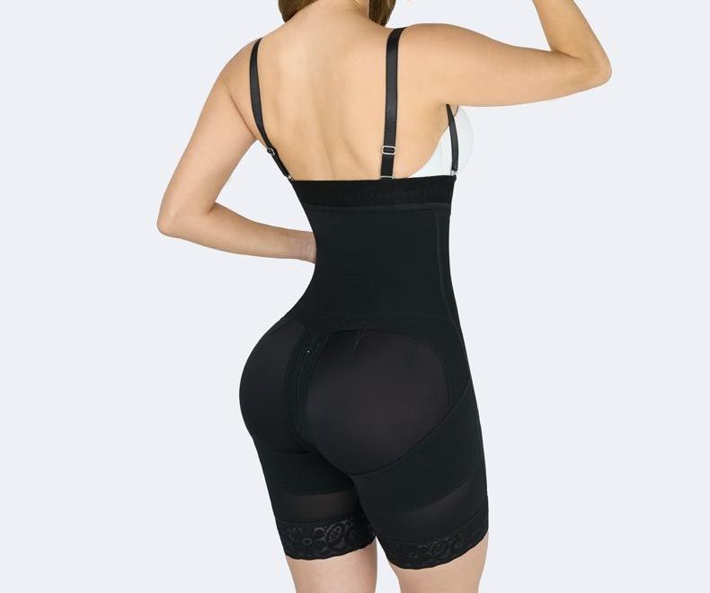 Black full-body shapewear on a person, back view. Includes straps, shorts, and butt shaping.