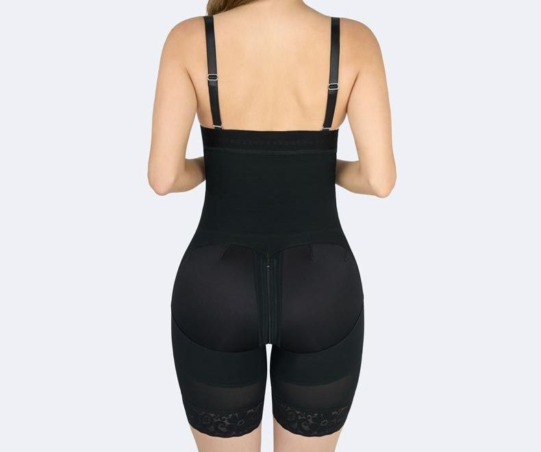 Woman wearing a black shapewear bodysuit, back view.