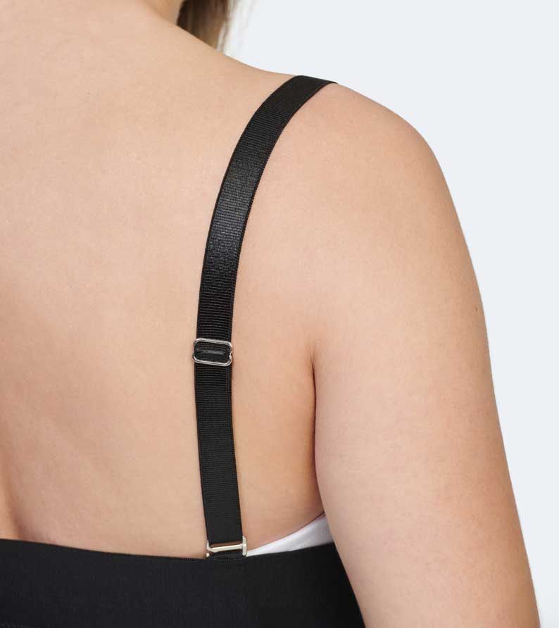 Black dress strap with adjustable metal hardware on a person's shoulder.