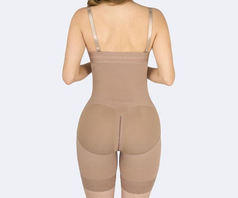 Beige body shaper garment with straps, covering torso and legs, featuring padded buttocks.