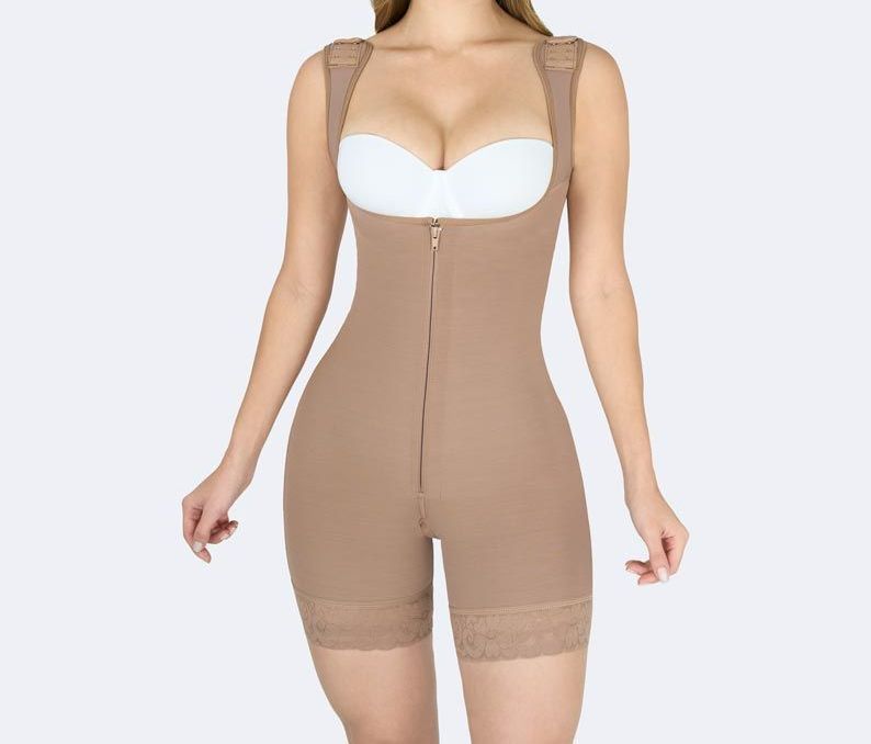 Tan full-body compression garment with front zipper, worn by a person with a white bra.