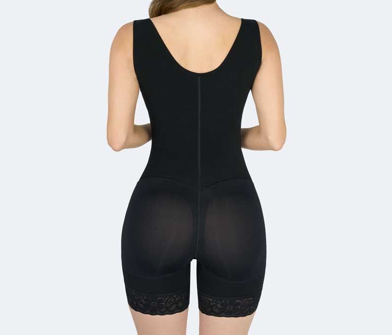 Back view of a person wearing a black compression bodysuit with shorts and lace trim.