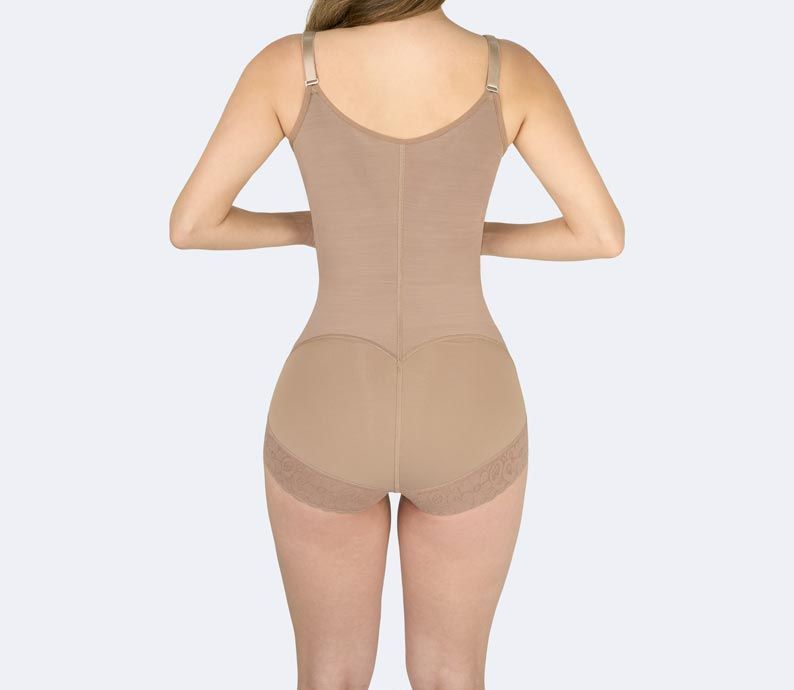 Woman wearing a tan shapewear bodysuit, back view.