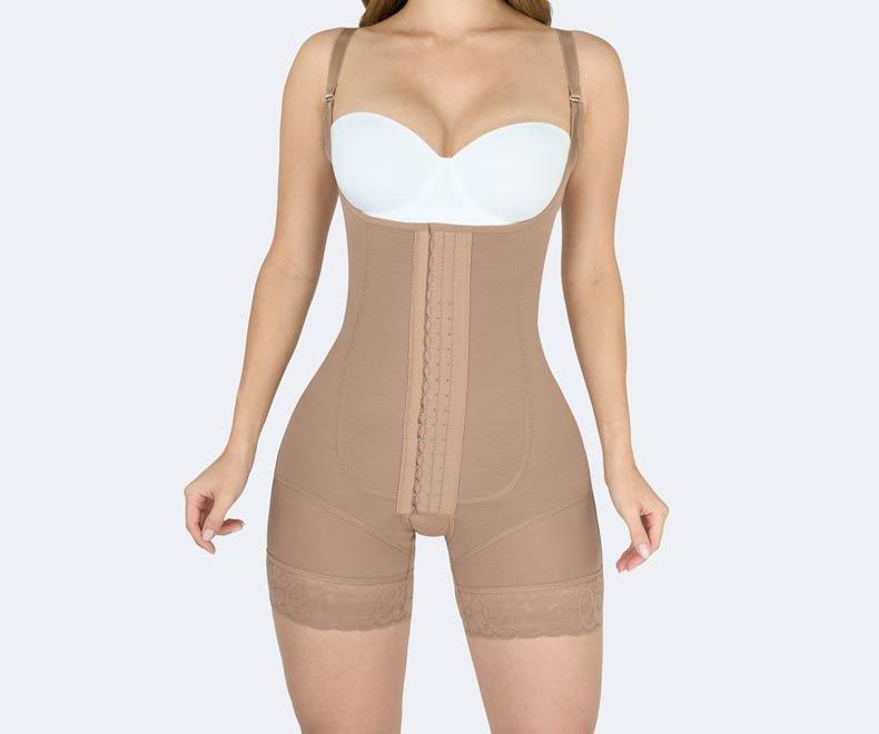 Beige body shaper garment with adjustable straps worn by a person with a white bra.