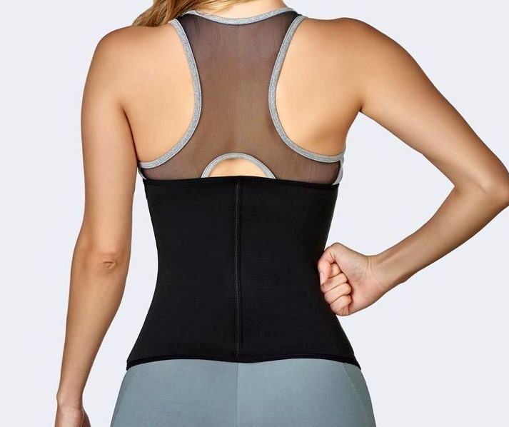 Woman wearing a black waist trainer and gray athletic wear; back view.