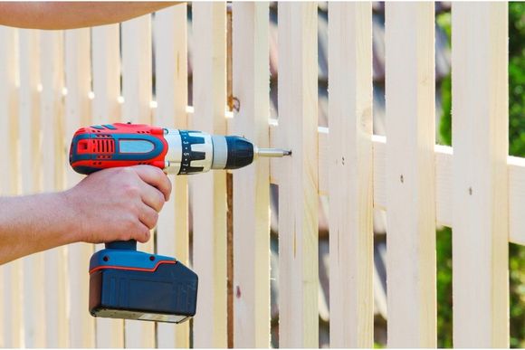 fixing wooden fence with a drill