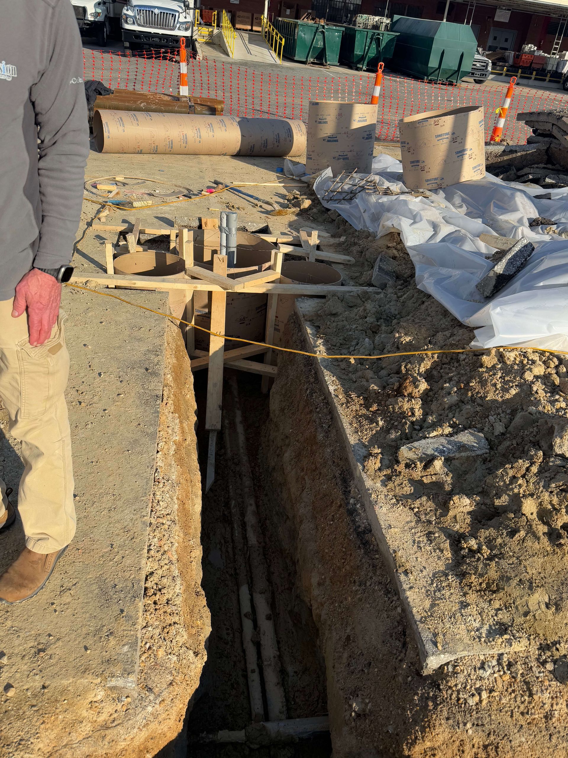 A man is standing next to a large hole in the ground