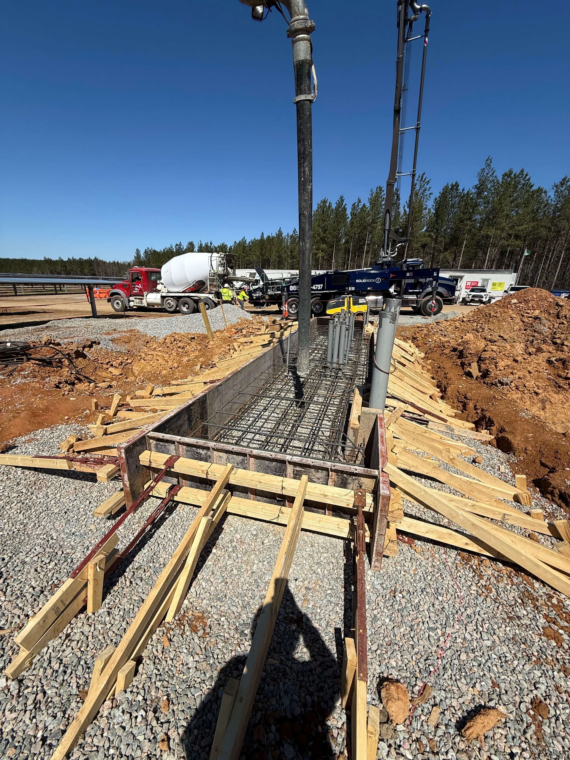 A concrete pump is being used to pour concrete into a hole.