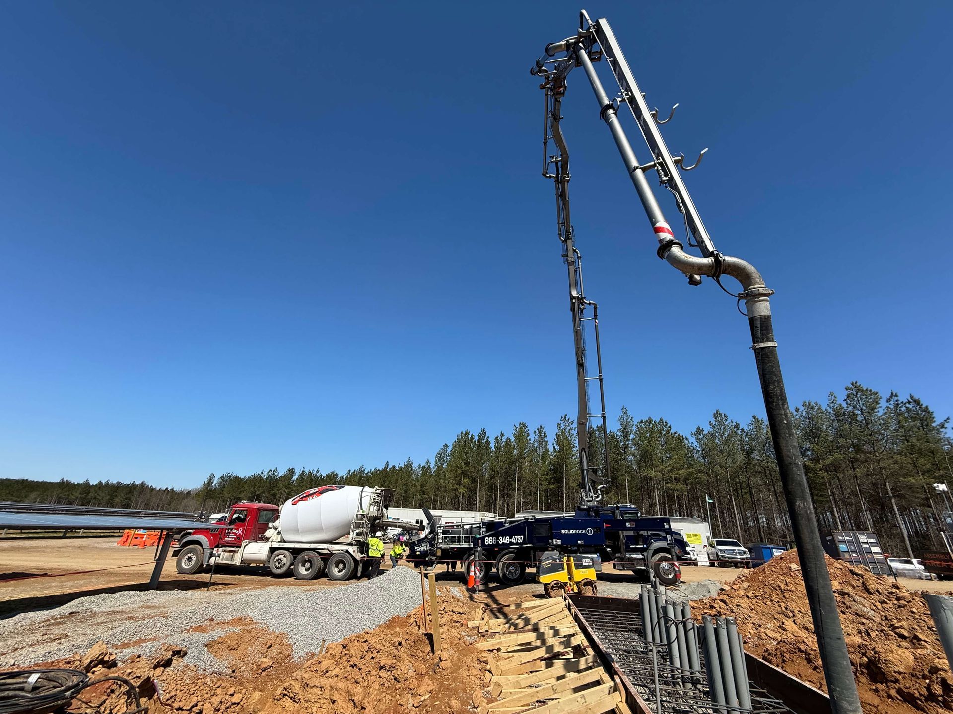 A concrete pump is being used to pour concrete on a construction site.