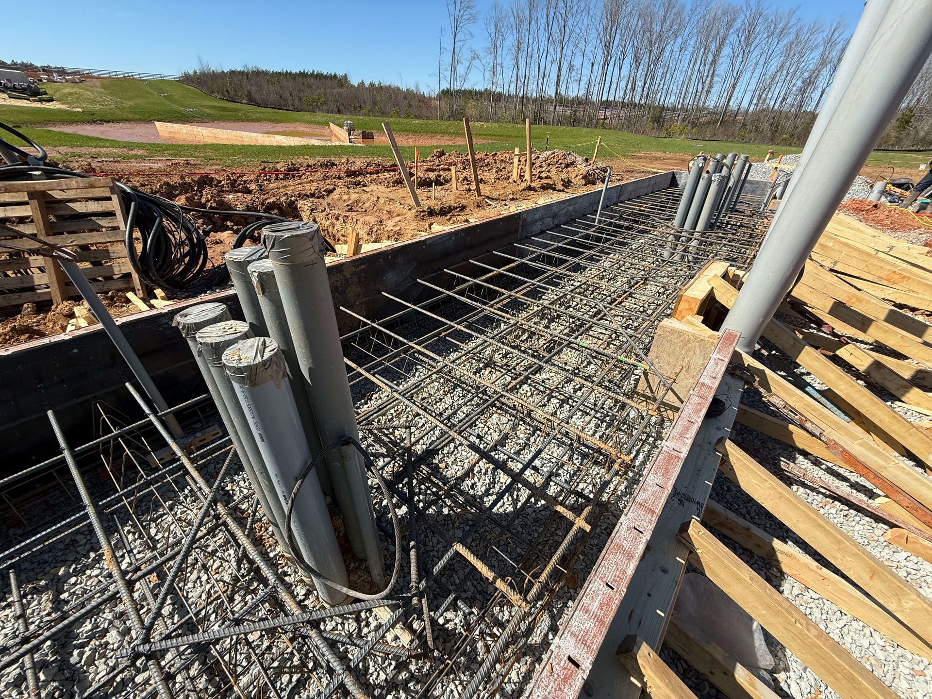 A construction site with a lot of pipes in the ground
