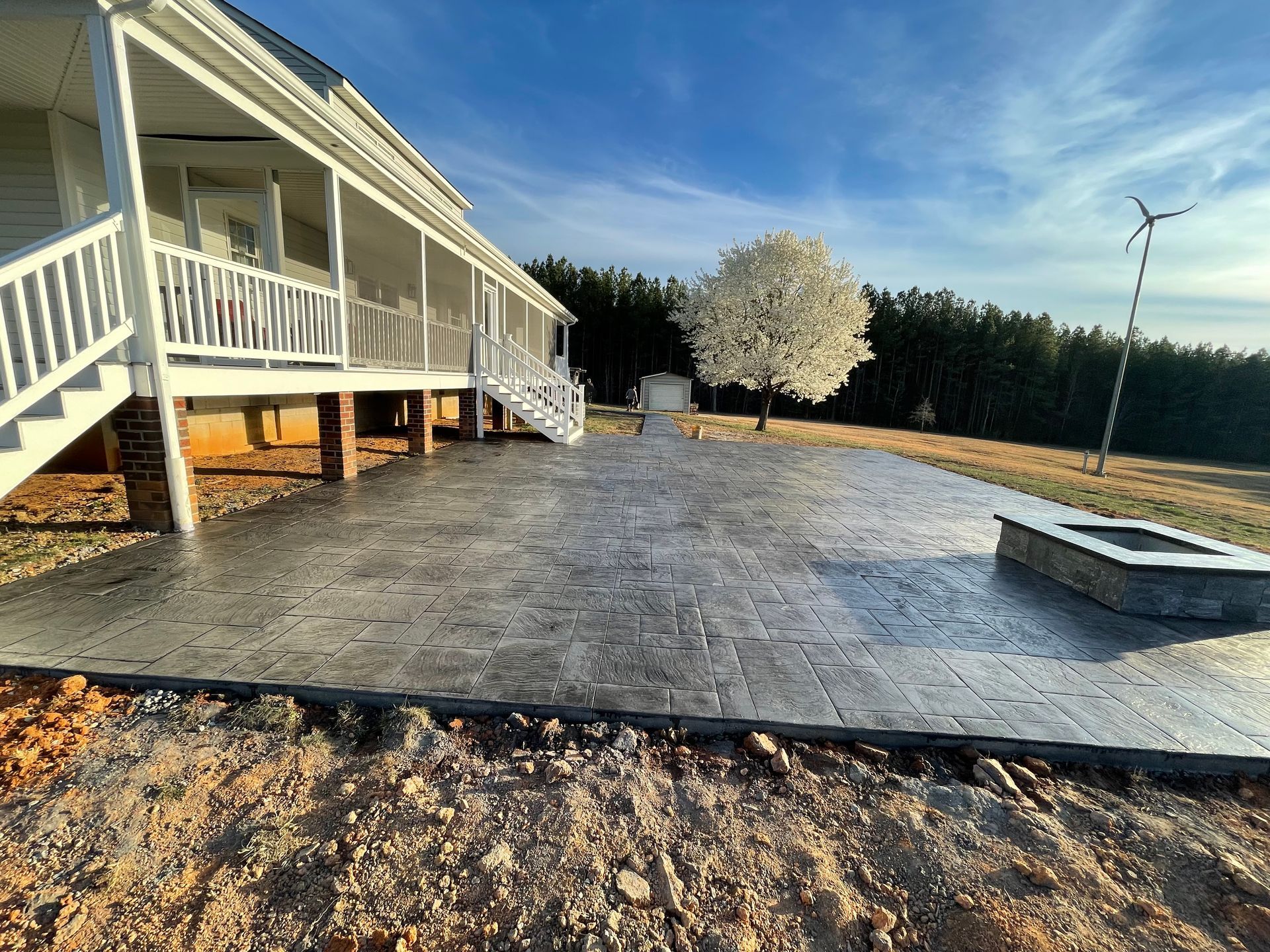 A large house with a large patio and a fire pit in front of it.