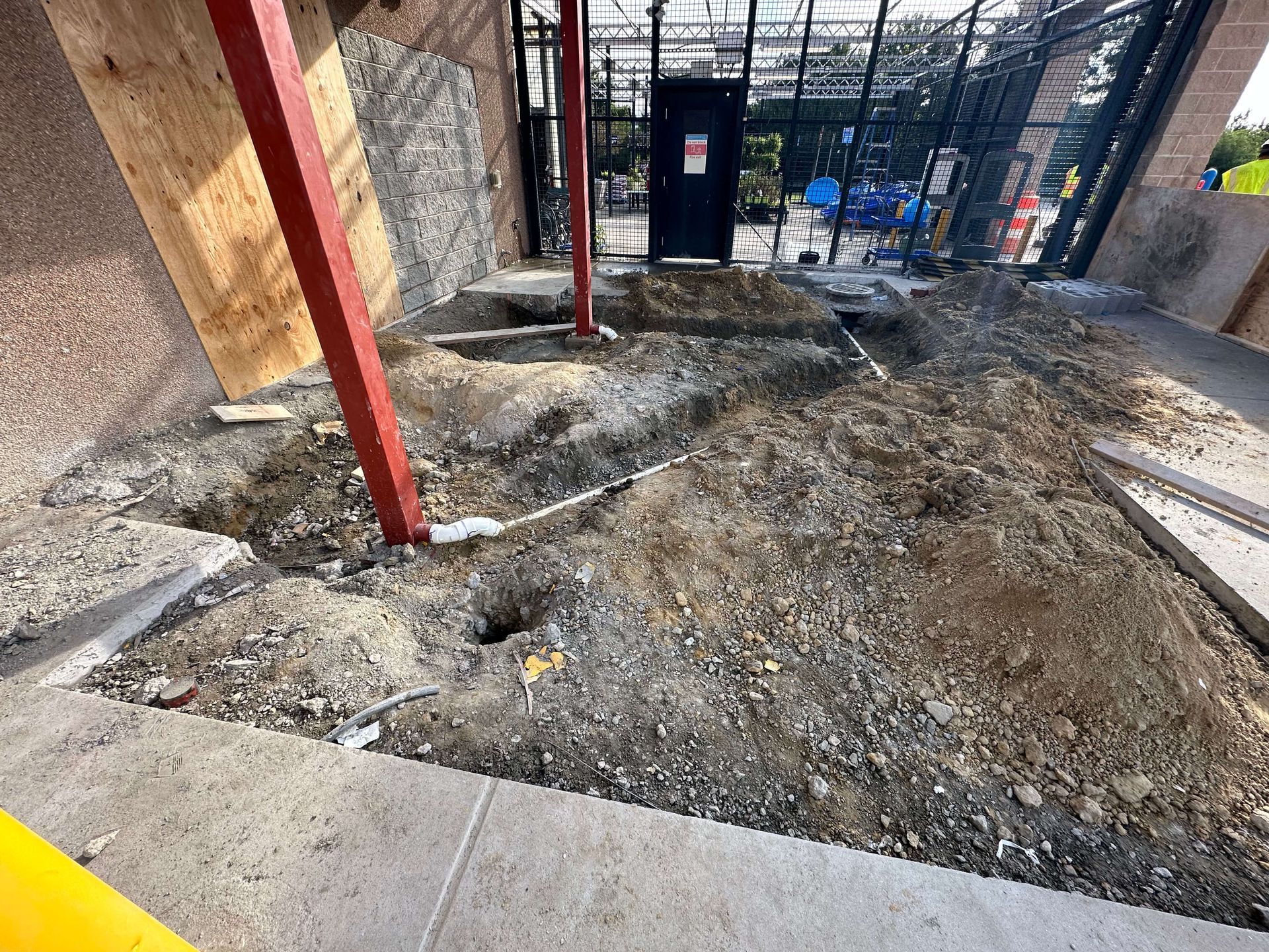 A concrete walkway in a garden with a wooden bench in the background.
