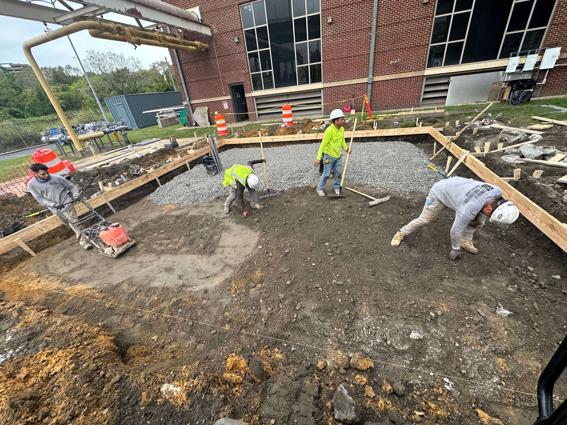 A brick house with a concrete driveway in front of it.