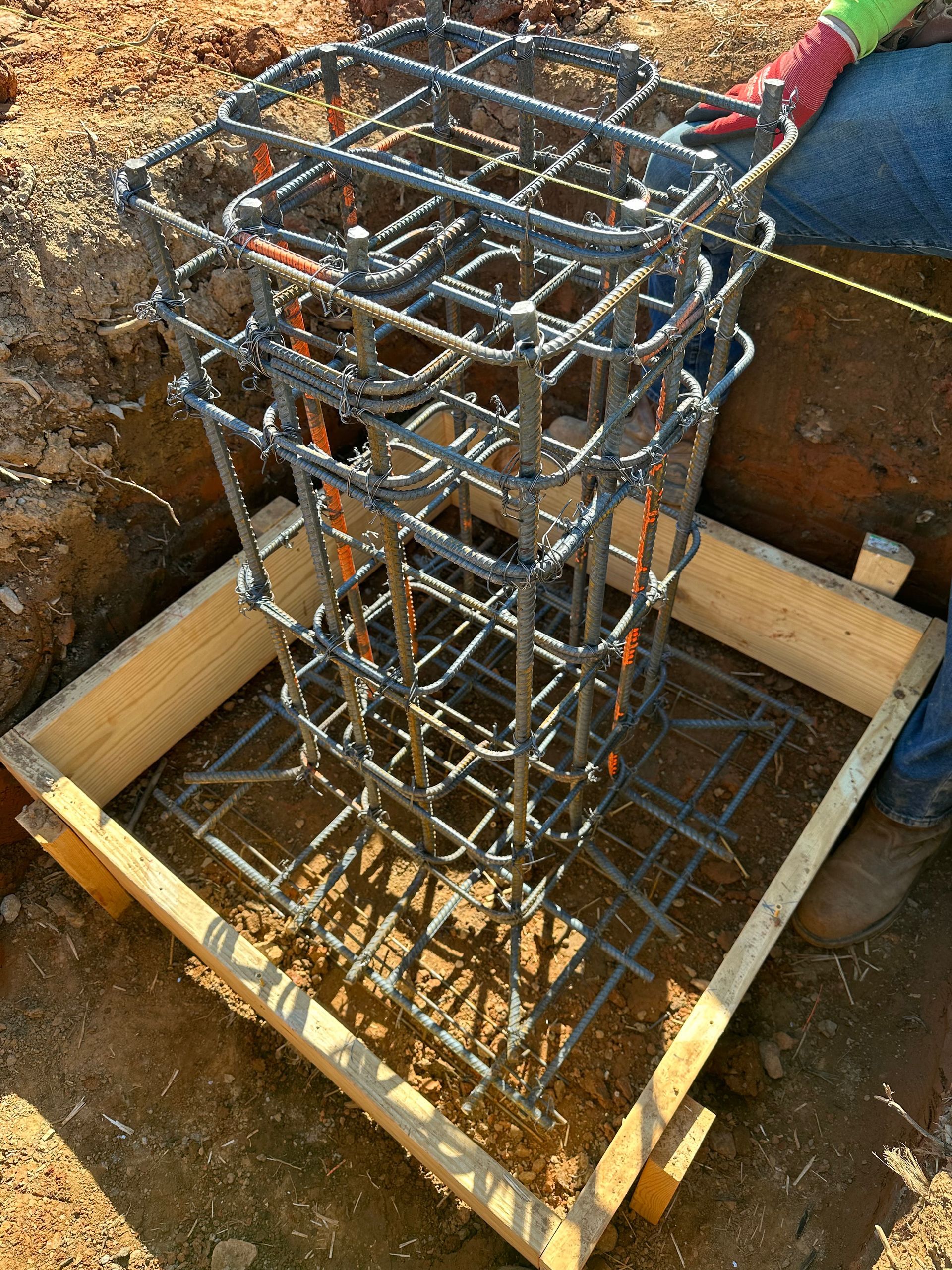 A person is sitting on a wooden box with a metal cage on top of it.