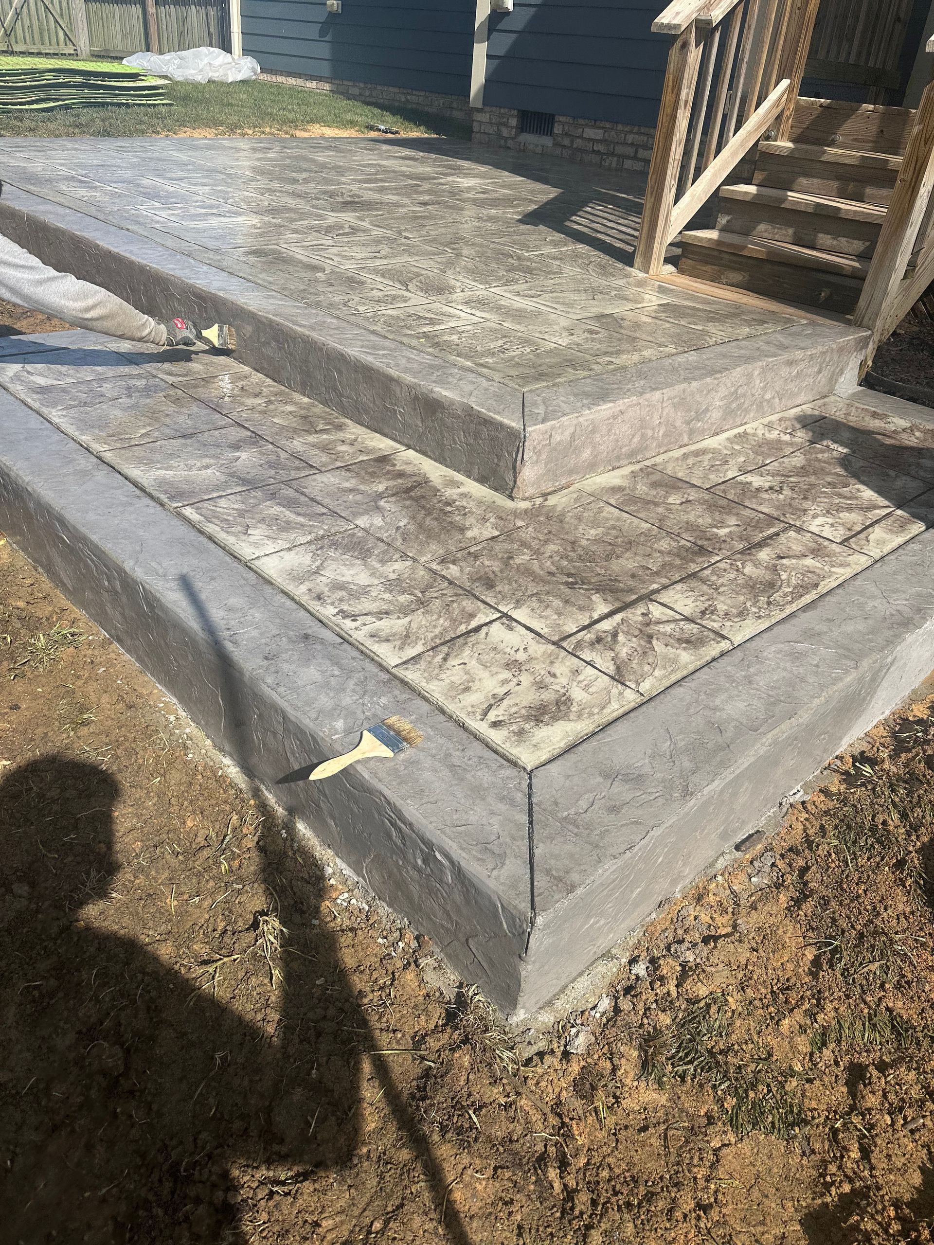 A concrete porch with stairs being built next to a house.