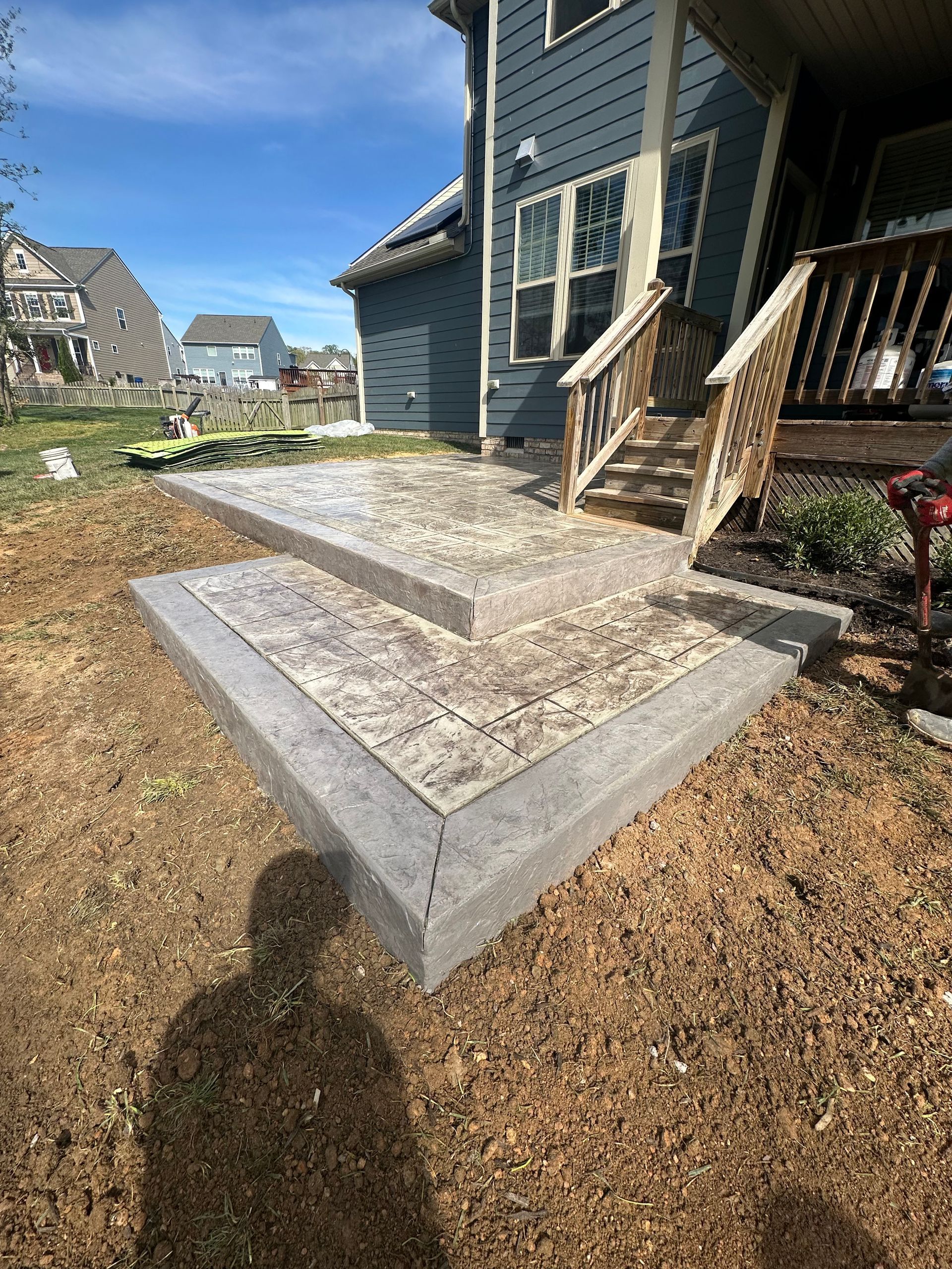 A concrete patio with stairs leading up to a house.