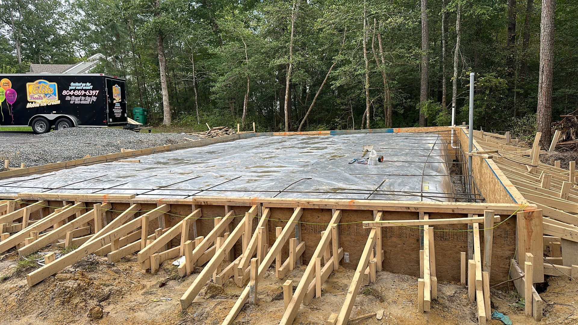 A brick house with a concrete driveway in front of it.