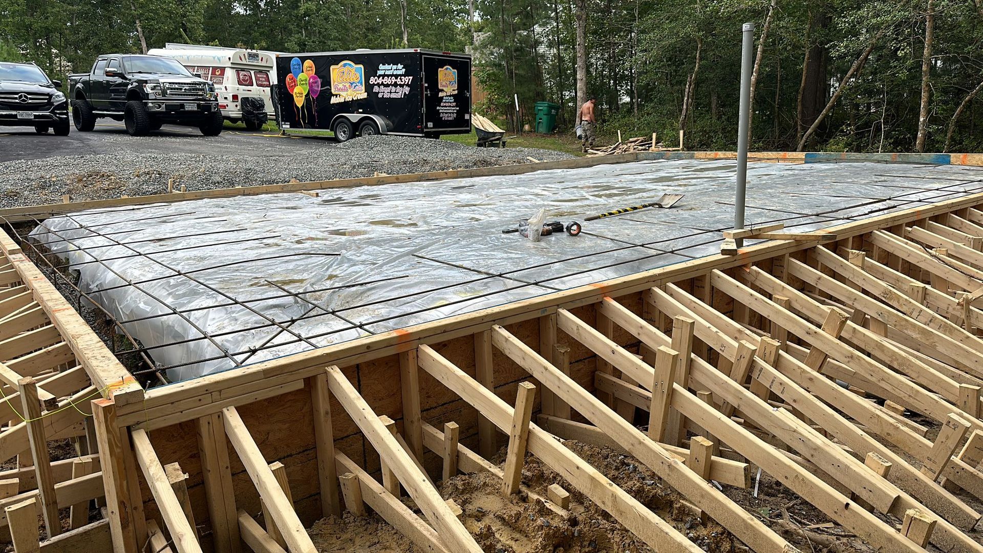 A concrete driveway with red cones on the side of it.