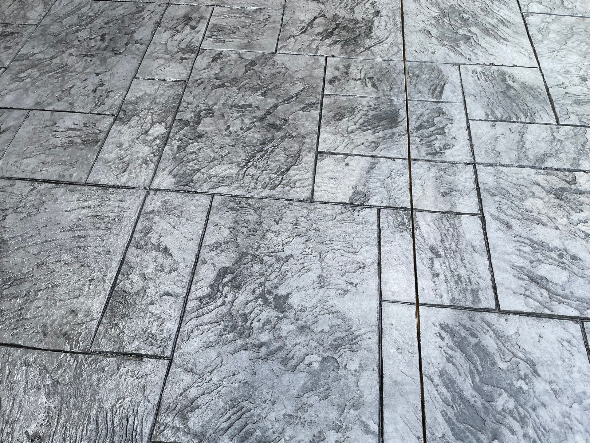 A close up of a gray tiled floor with a marble texture.