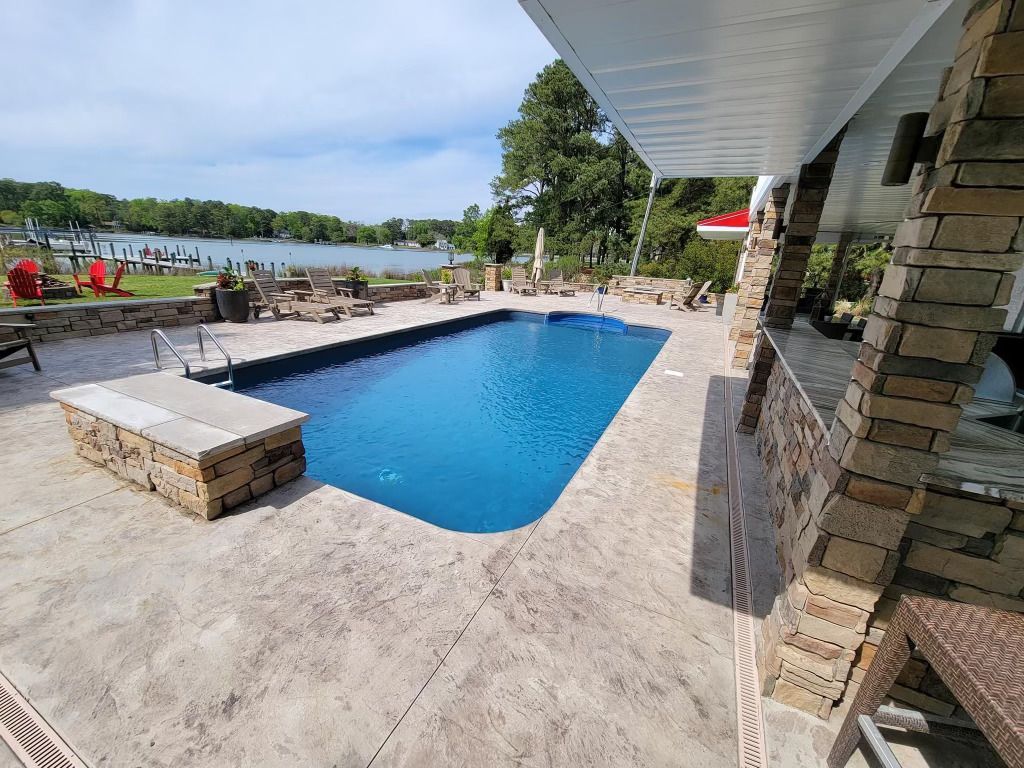 There is a large swimming pool in the backyard of a house.