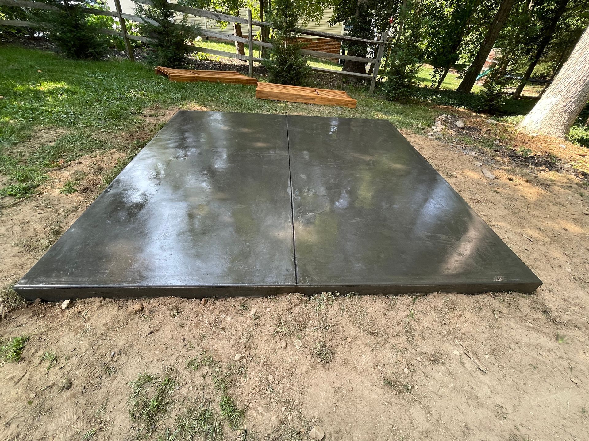 A large concrete slab is sitting on top of a dirt field.