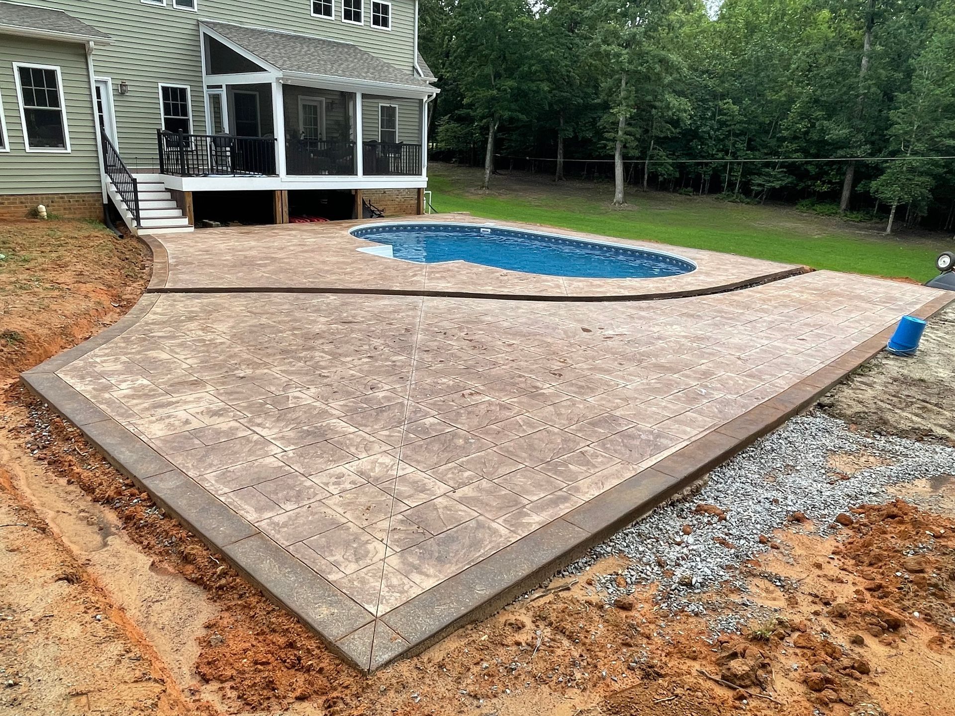 A patio with a pool in the backyard of a house.