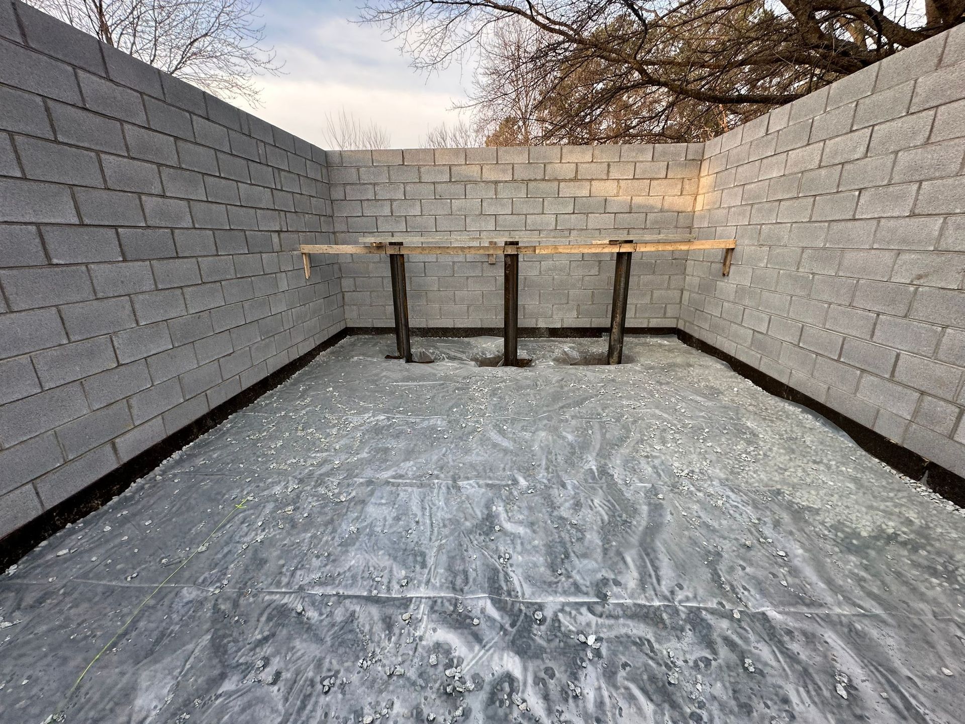 A concrete driveway with red cones on the side of it.