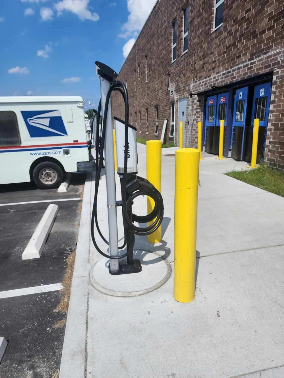 A united states postal service truck is parked in a parking lot