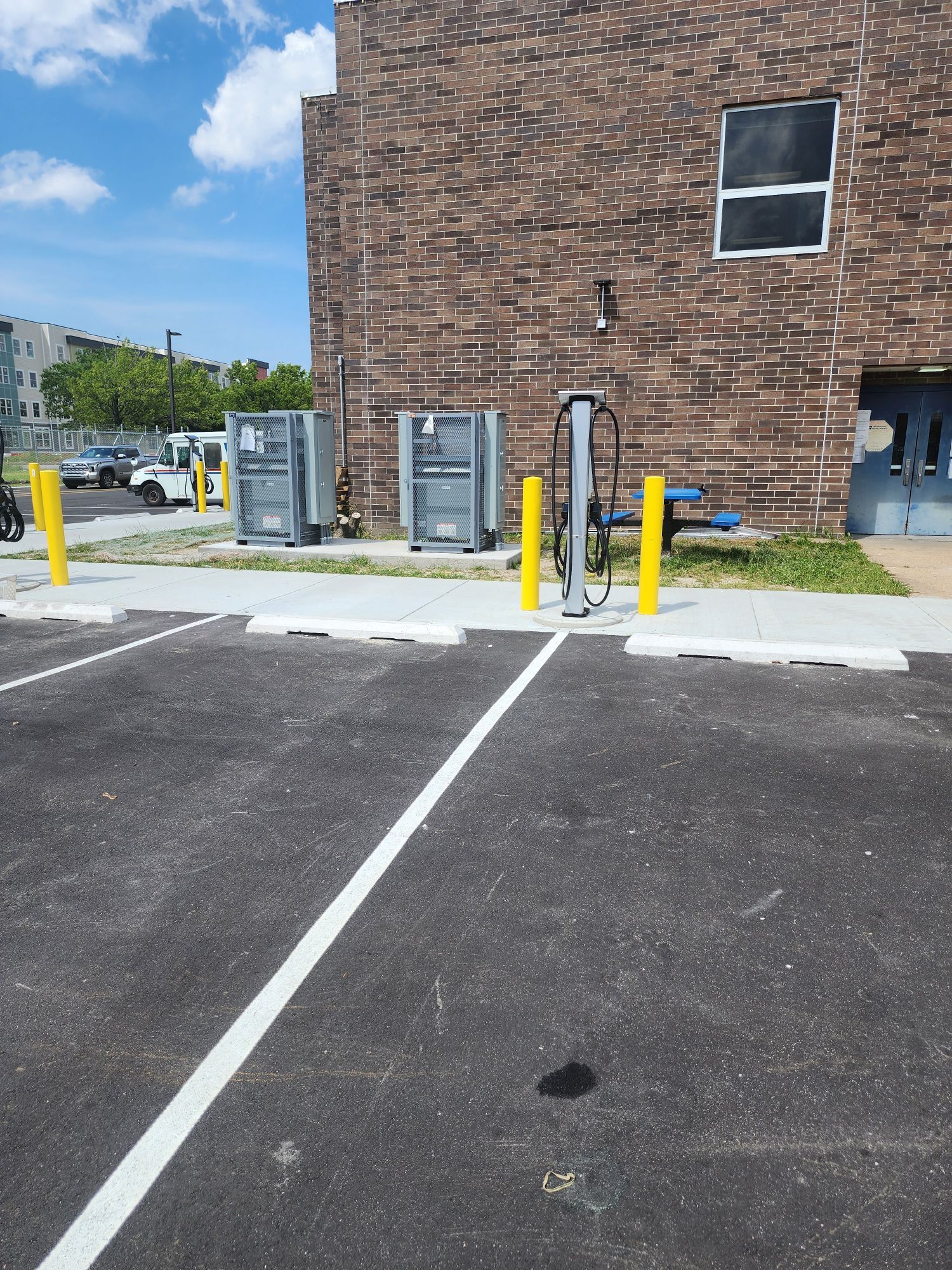 A parking lot with a brick building in the background