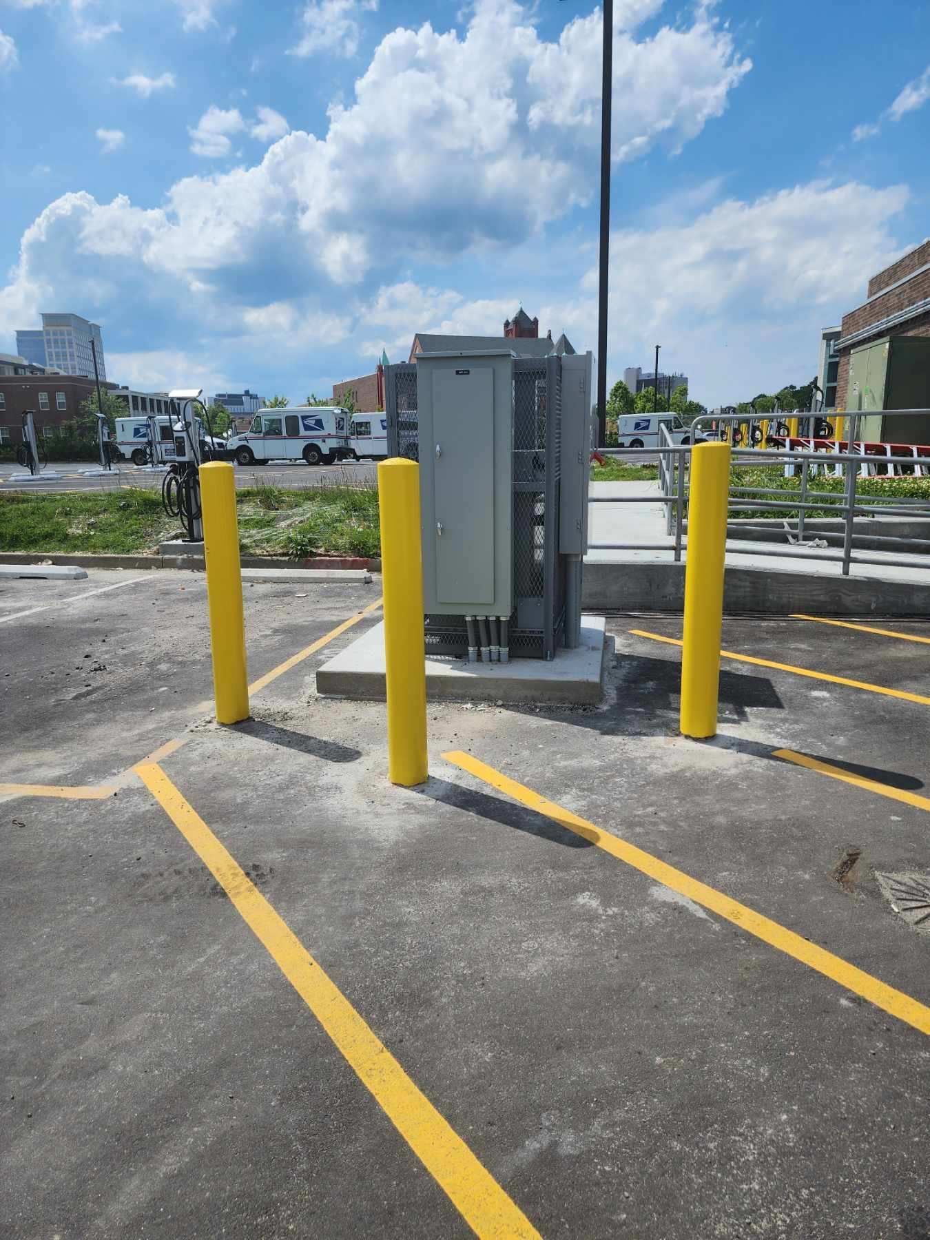 A parking lot with yellow poles and a box in the middle