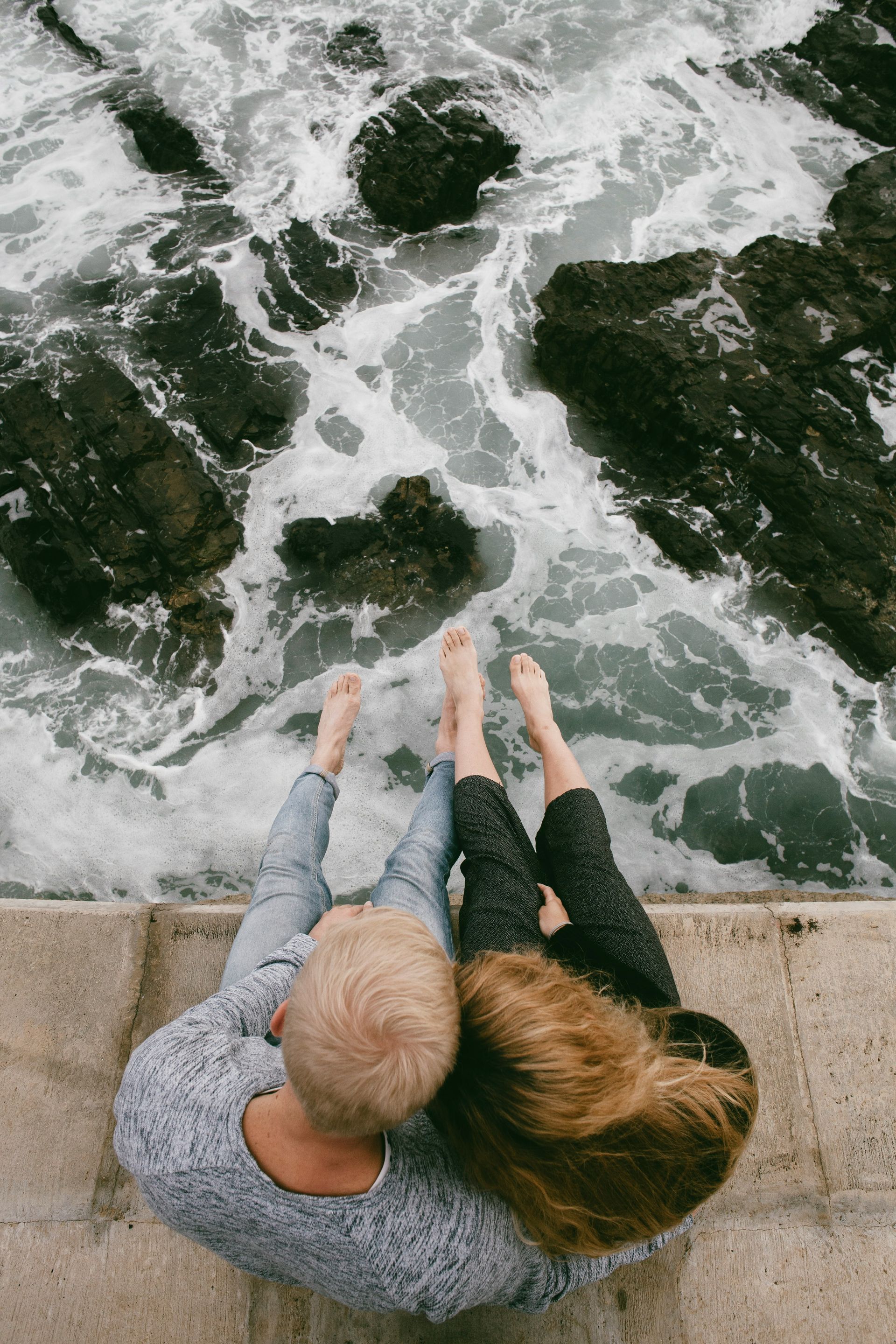 A couple sitting on a wall by the ocean thinking about their 2026 insurance coverage changes as recommended by Chehalem Insurance Associates. 
