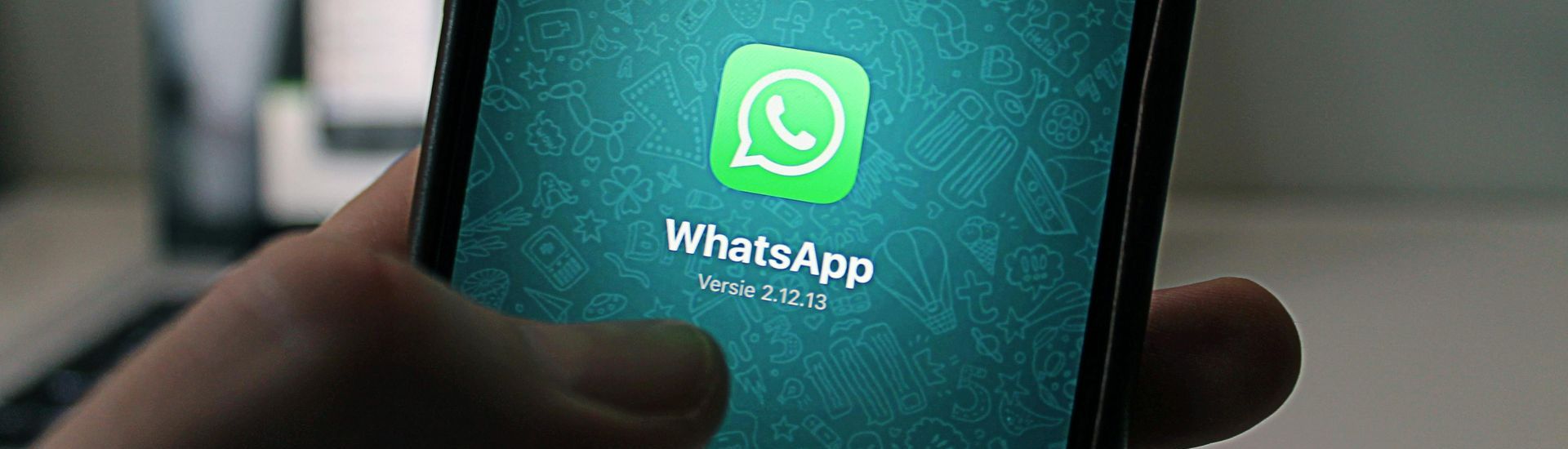 Uma pessoa está segurando um celular com o aplicativo WhatsApp nele.