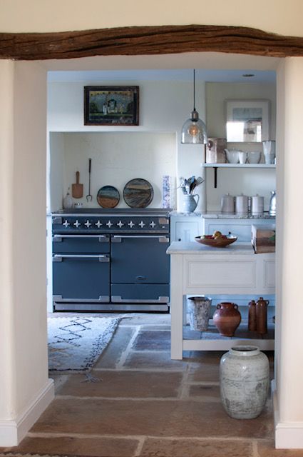 A heritage style home with an interior design made up of authentic stone floor and a wooden arch beam between rooms.