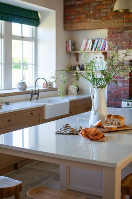 Heritage styled kitchen with exposed brick walls and a farmhouse sink.