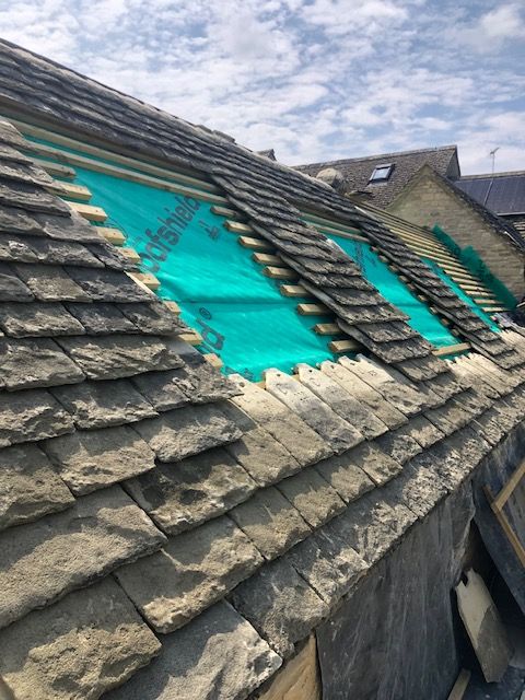 Stone roof with roof lights being installed