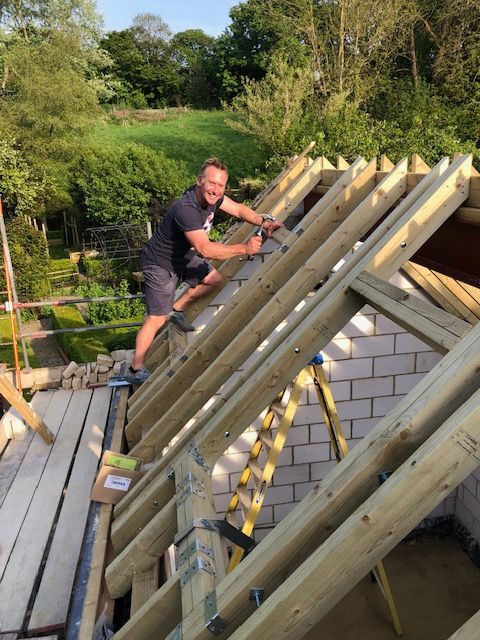 Seth Dixon performing a roof installation with exposed timber.