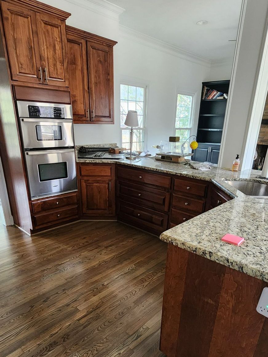 A kitchen with wooden cabinets , granite counter tops , and stainless steel appliances - Harrodsburg, KY Southern Elite Coatings LLC 