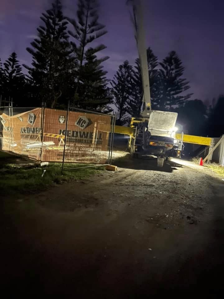 A Large Crane is Sitting on Top of a Dirt Road at Night — Mackie's Concrete Pumping In Taree, NSW