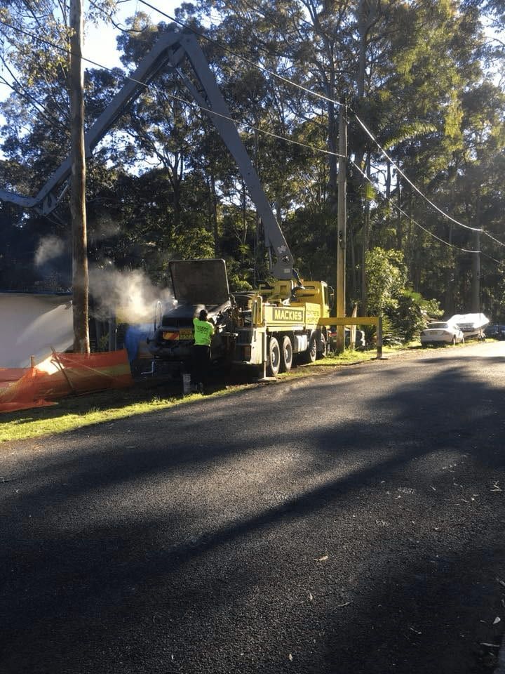 A Yellow Truck is Parked on the Side of a Road — Mackie's Concrete Pumping In Wingham, NSW