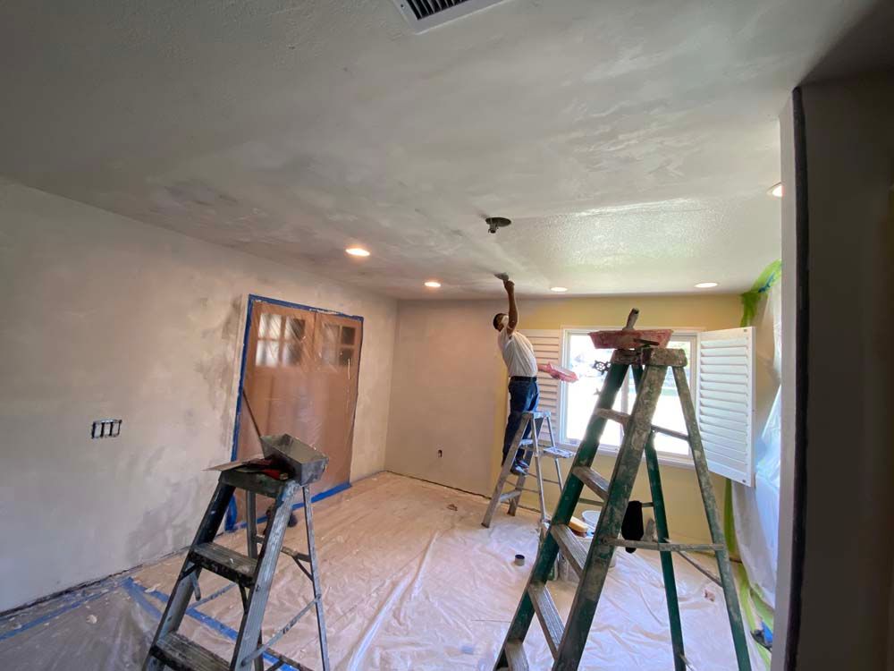 Professional Worker Painting Ceiling White