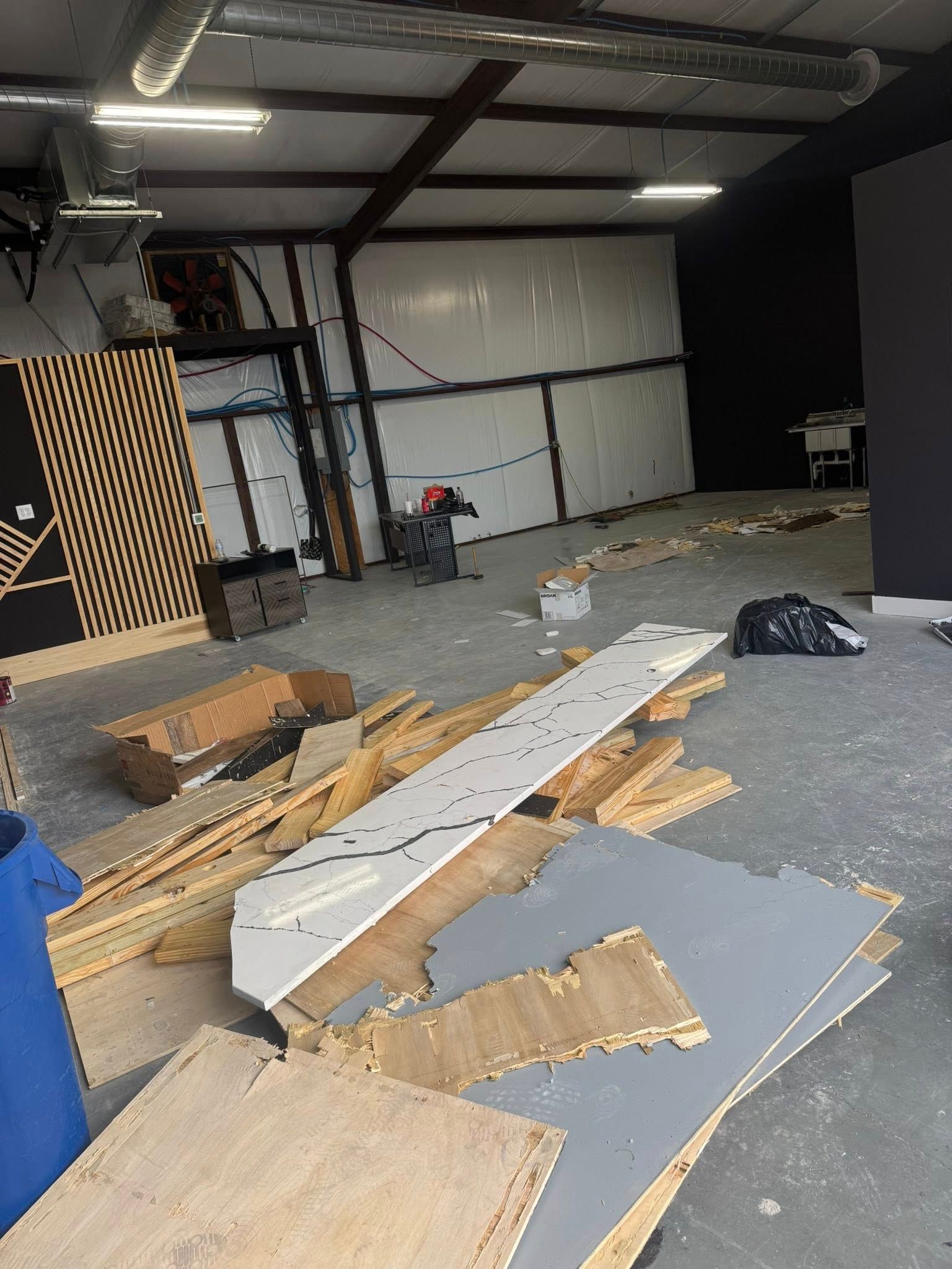 Interior of a construction site with debris on the floor and unfinished walls.