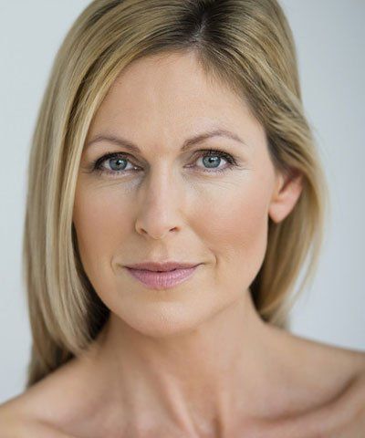 A close up of a woman 's face with blonde hair and blue eyes.