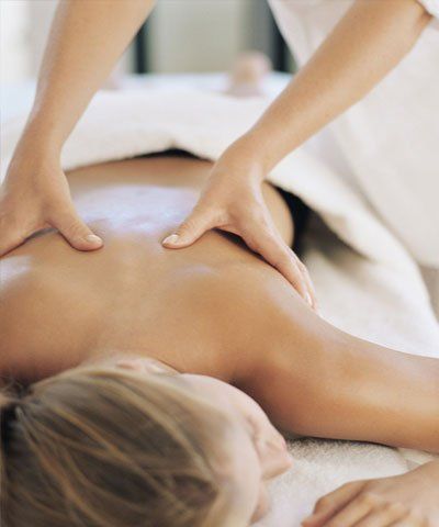 A woman is getting a massage on her back at a spa.