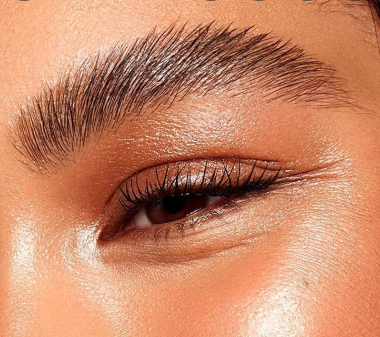 A close up of a woman 's eye with long eyelashes.