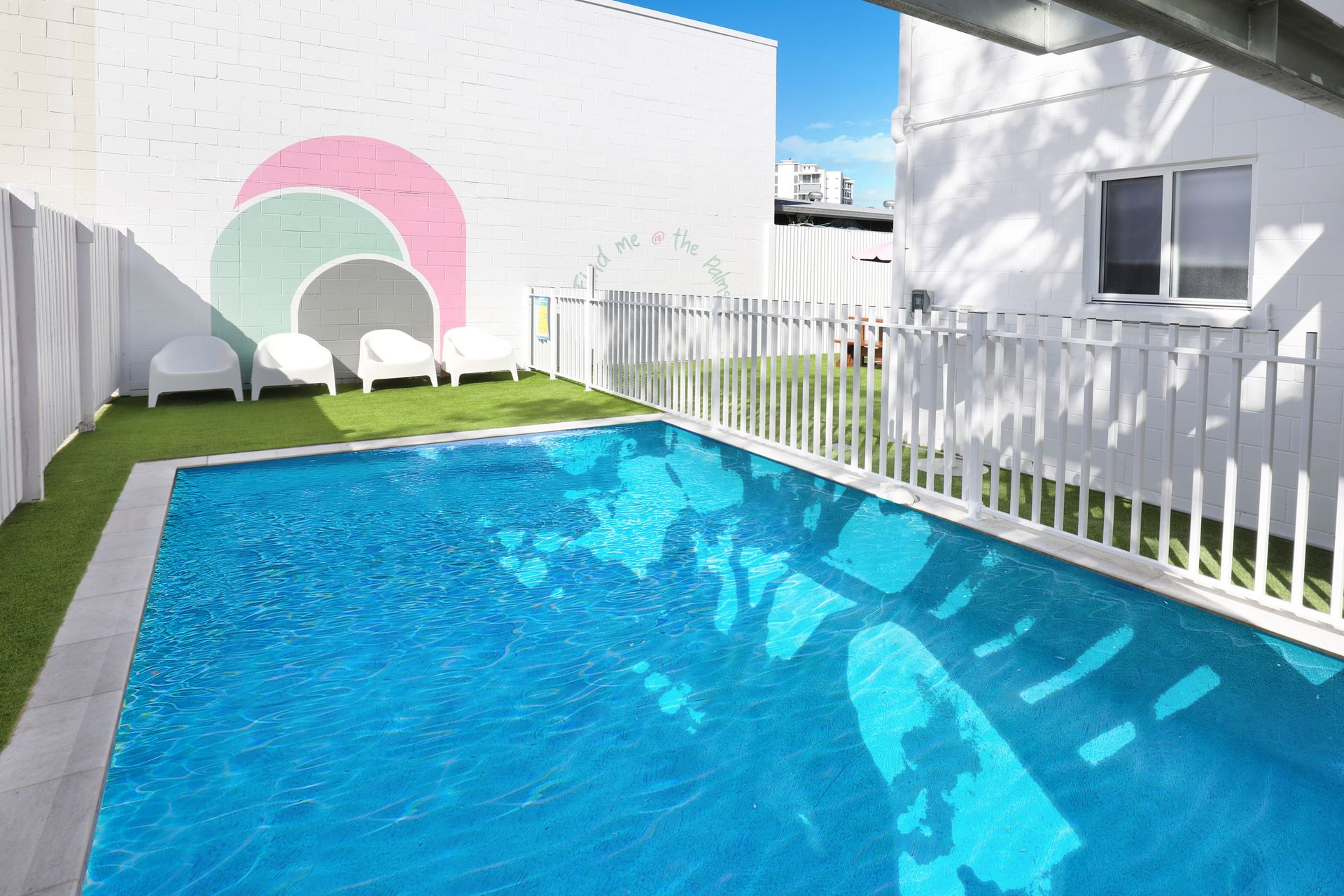 A large swimming pool with a white fence around it