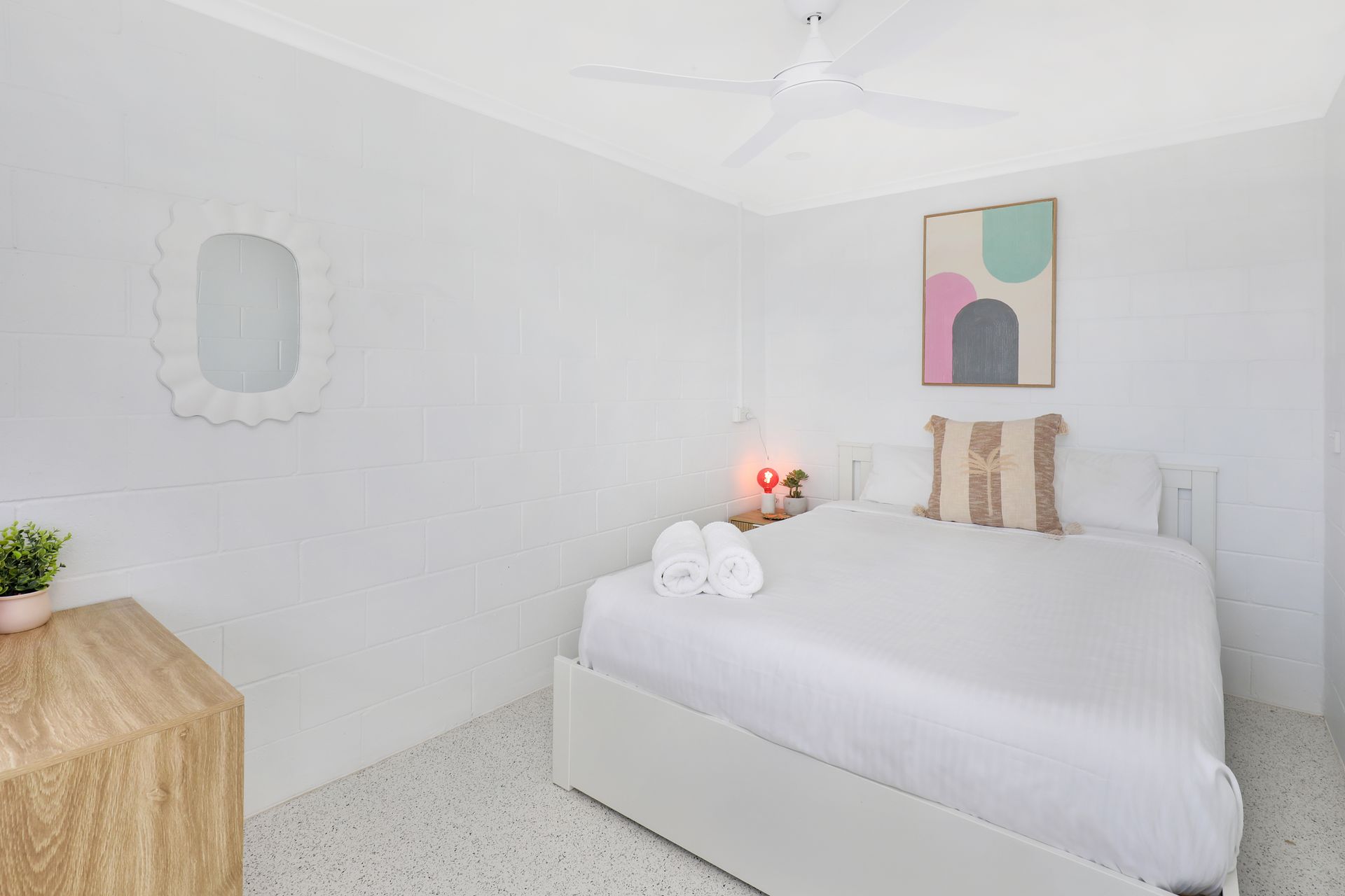A bedroom with a king size bed and a ceiling fan.