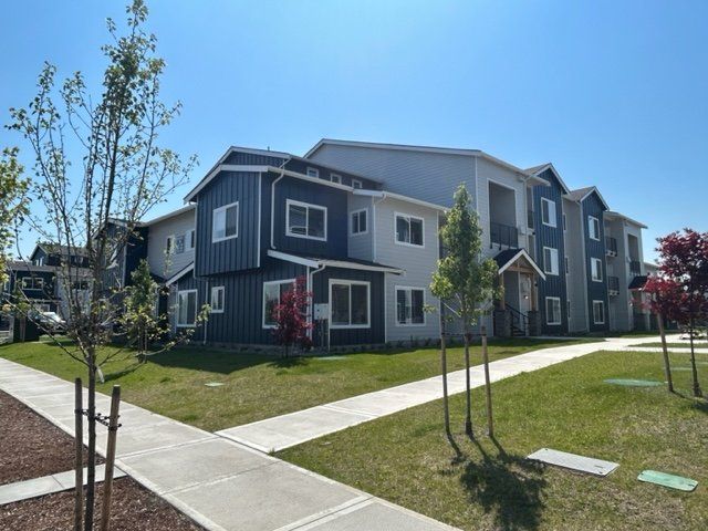 A large apartment building with a sidewalk in front of it